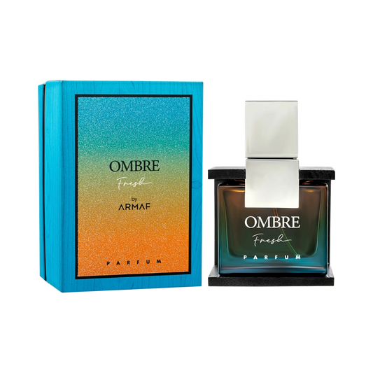 A bottle of OMBRE Fresh Parfum by Armaf stands next to its blue packaging box on a plain white background. The box features a vibrant blue-to-orange gradient design, and the glass bottle has a matching gradient tint with a reflective silver cap.