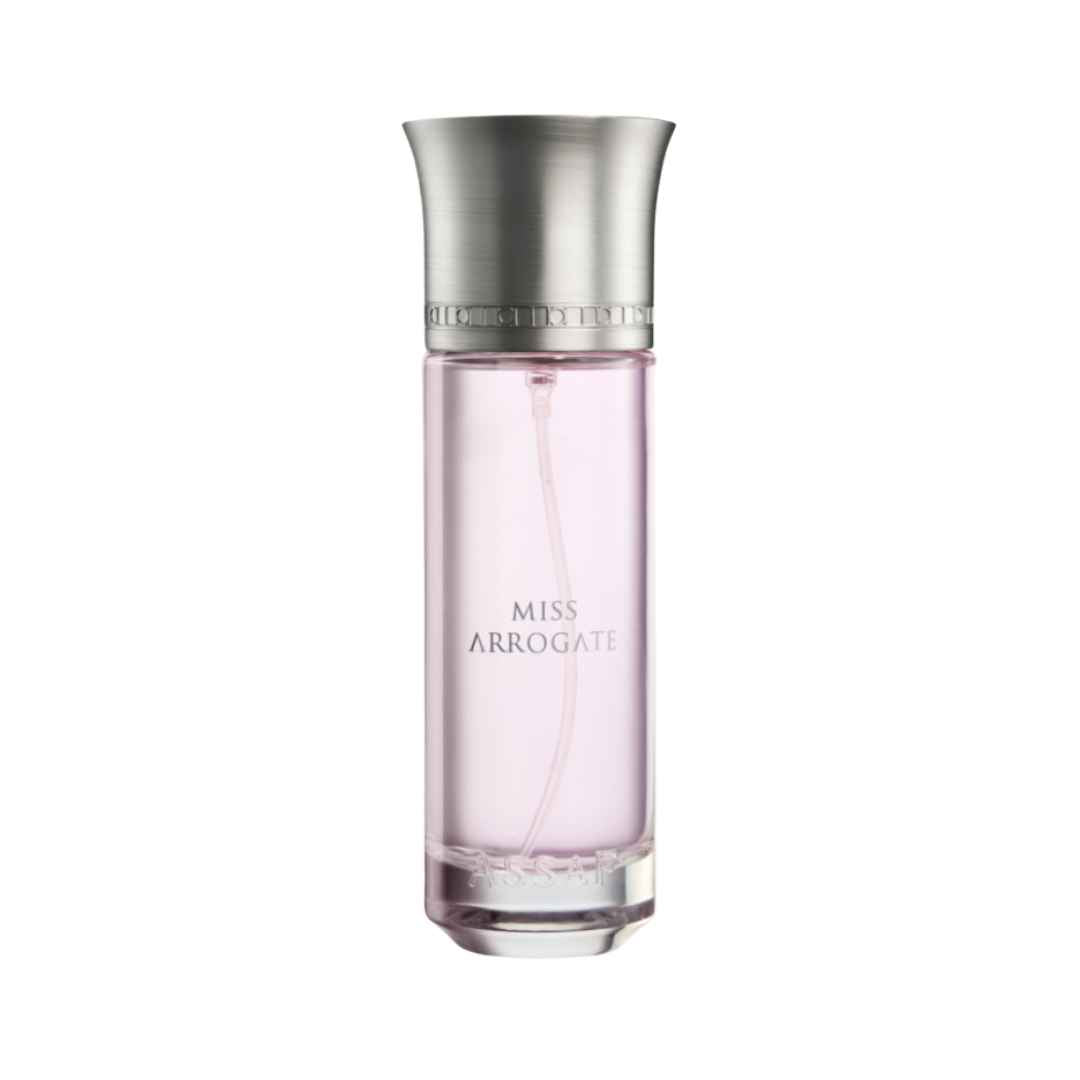 A bottle of ASSAF Miss Arrogate EDP for women with a clear pink liquid visible inside, a silver cap, and labeled name on the front.